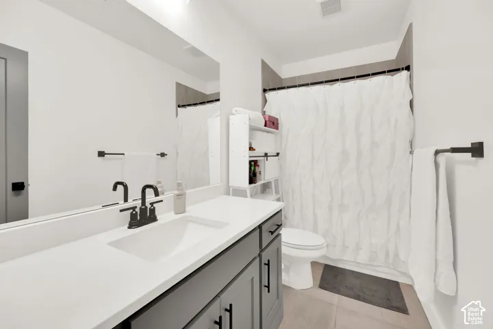 Full bathroom featuring vanity, light tile patterned floors, and shower / tub combo