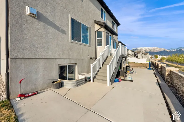 Rear view of property with a patio area, a mountain view, and stucco siding