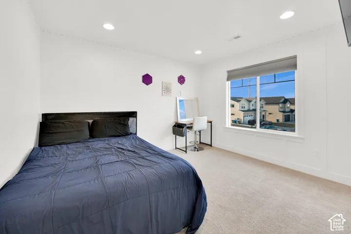 Bedroom featuring carpet floors, recessed lighting, and a decorative wall