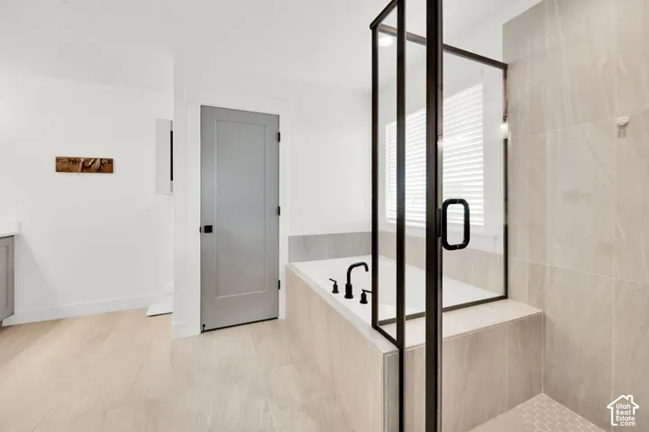 Bathroom featuring a garden tub, a shower stall, and vanity