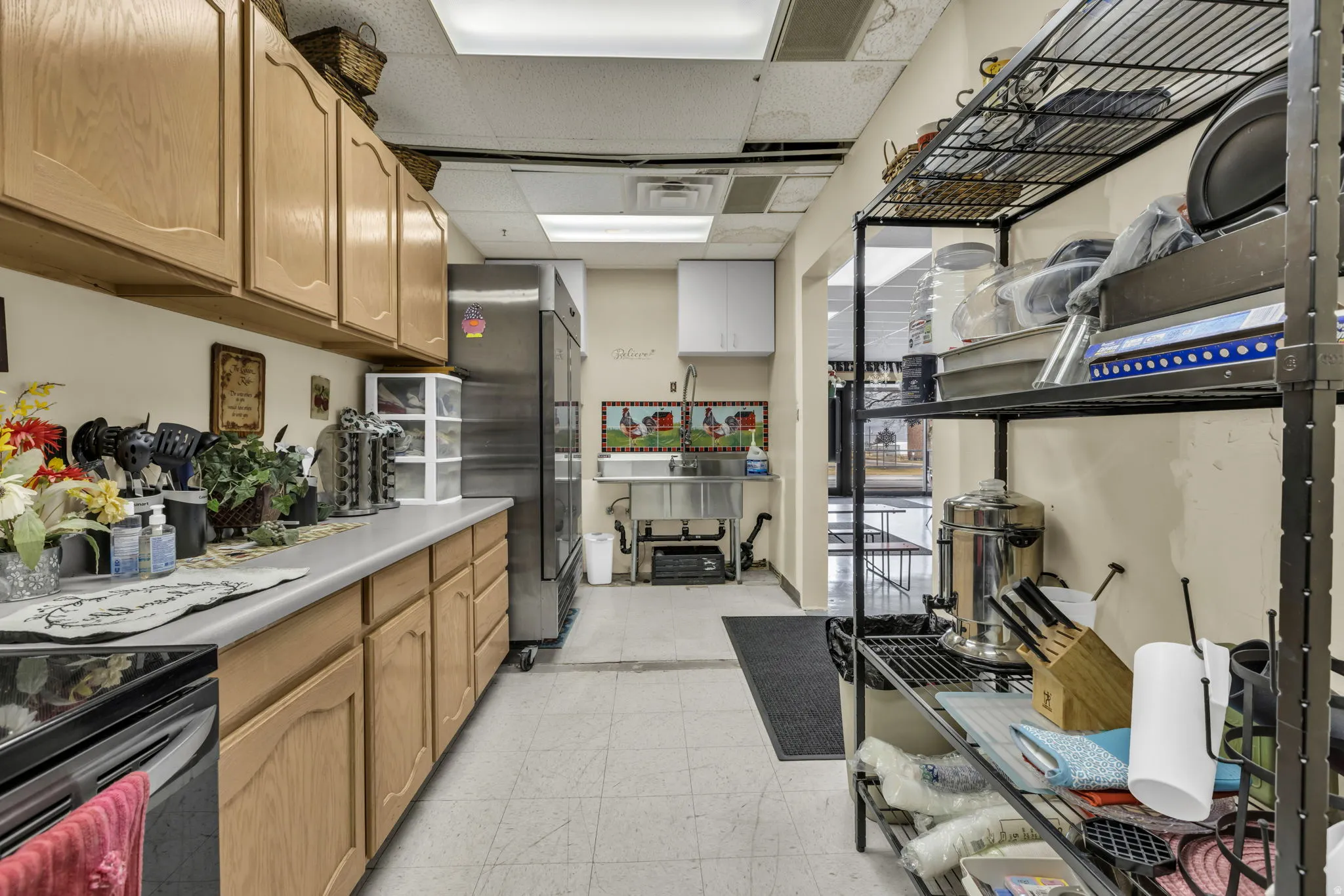 Kitchen with stainless steel appliances, light countertops, and a paneled ceiling