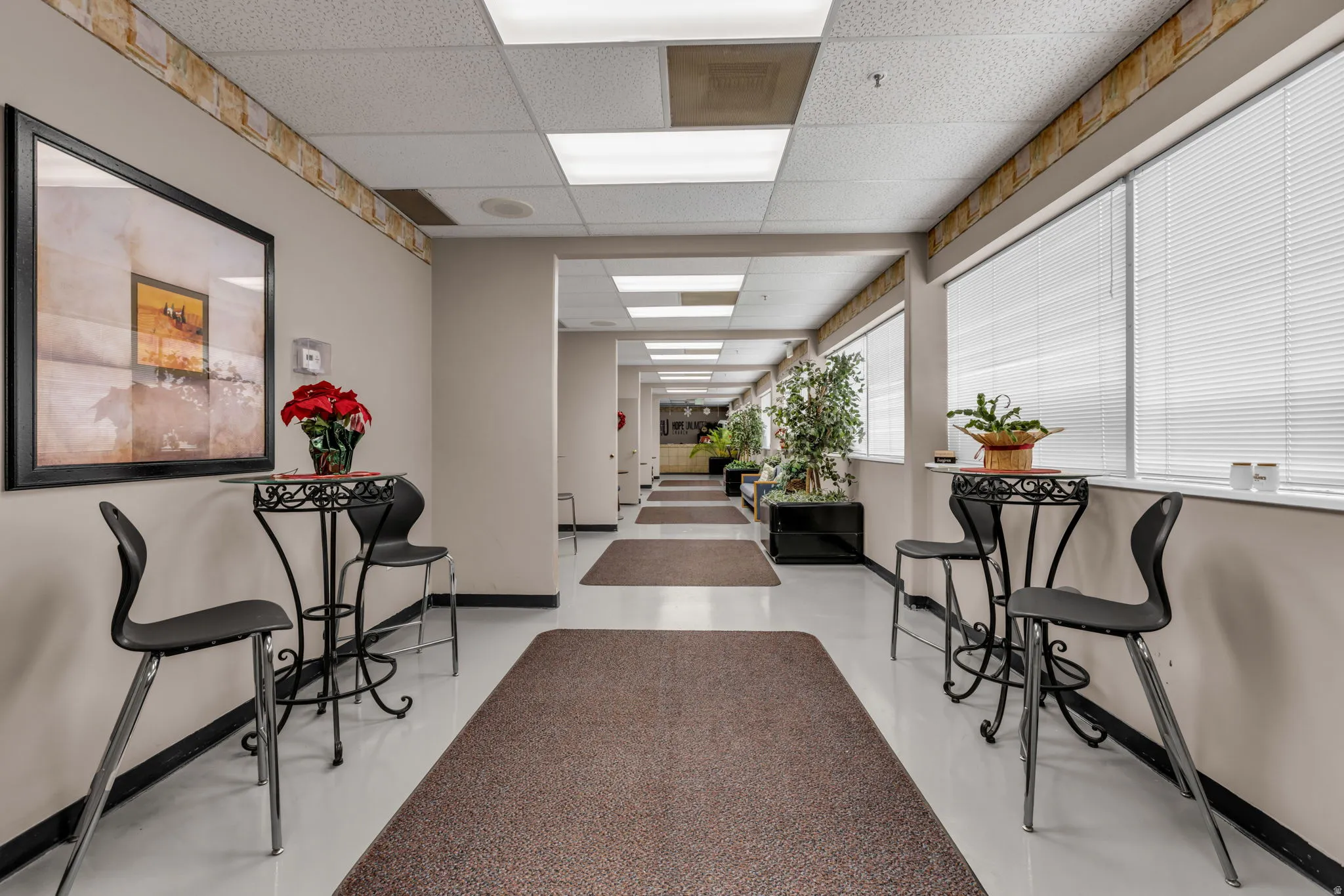 Hall featuring a paneled ceiling and finished concrete flooring