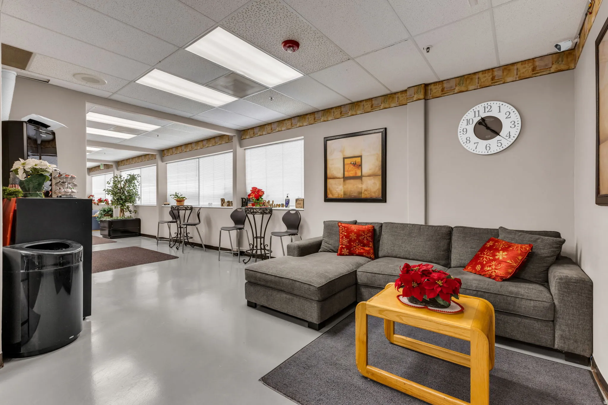 Living area featuring concrete flooring and a paneled ceiling