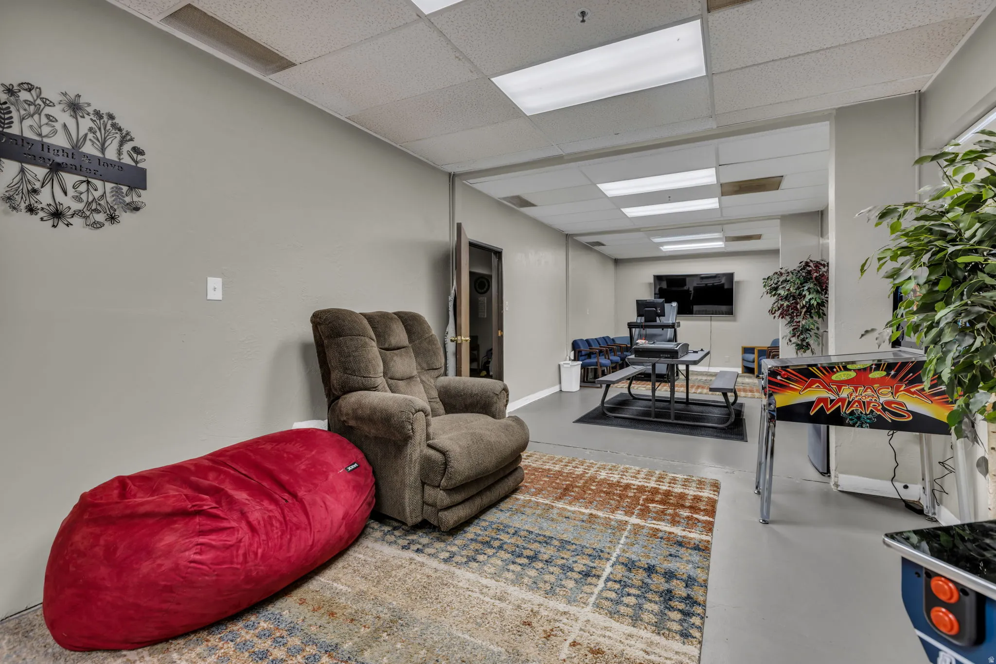 Living room with concrete flooring and a drop ceiling