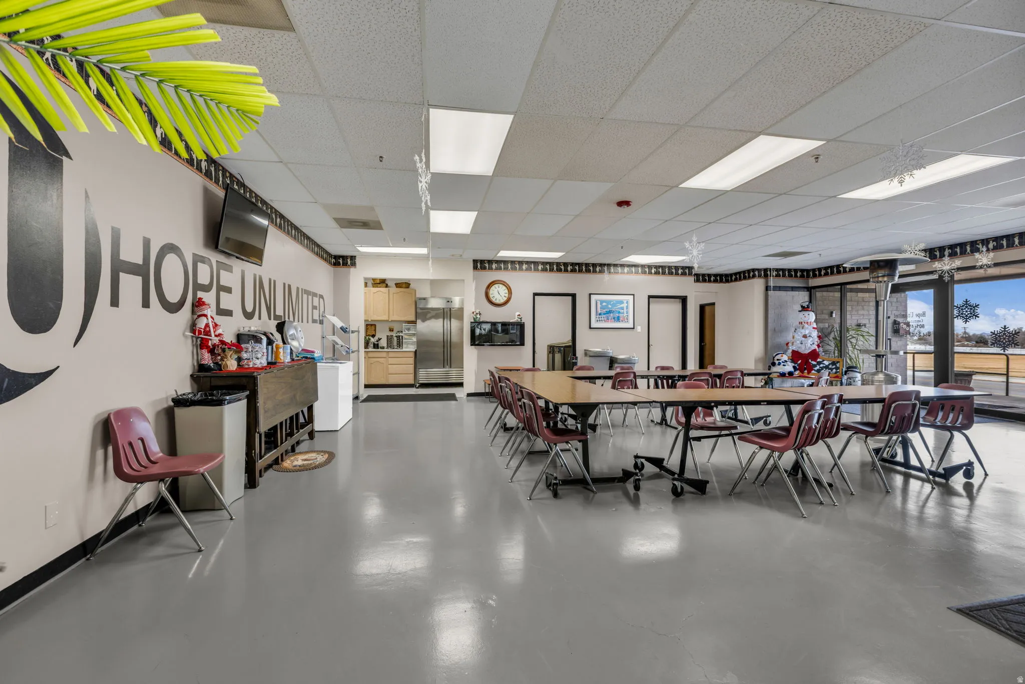 Dining space featuring finished concrete floors and a drop ceiling