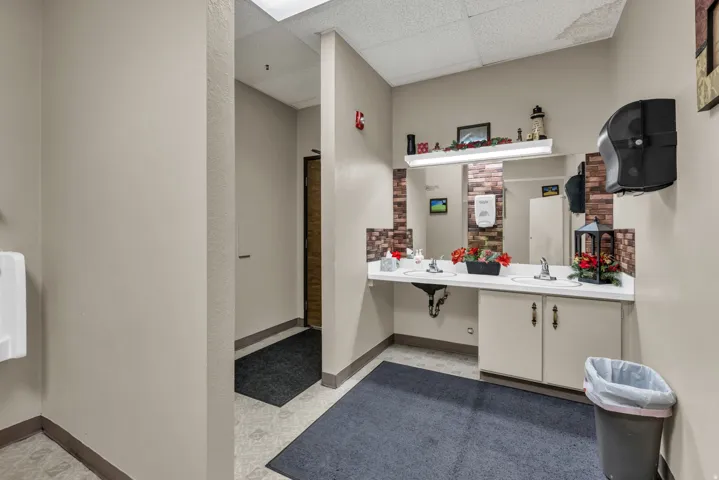 Bathroom featuring a drop ceiling and double vanity