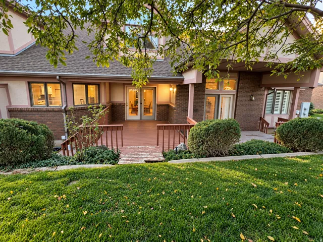 Rear exterior featuring a wood deck, brick accents, and multiple windows
