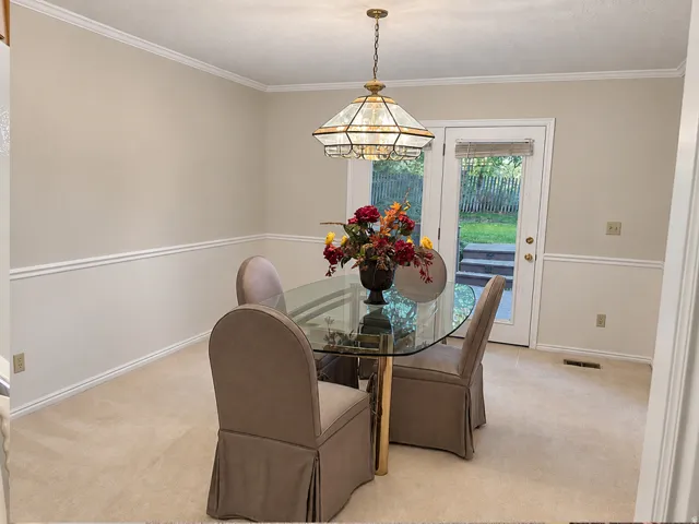 Recessed ceiling light, crown molding, chair rail molding, and a stained glass-style chandelier