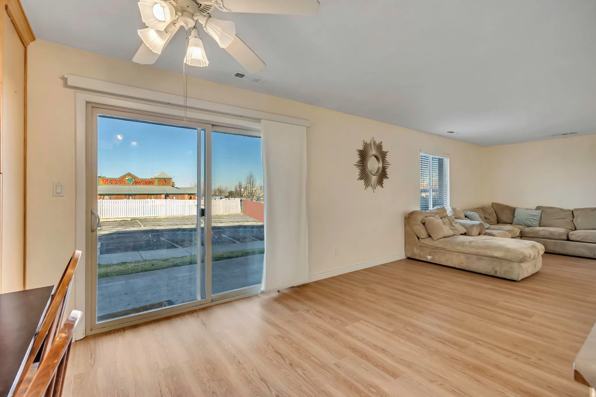 Living room with light wood-style flooring and a ceiling fan