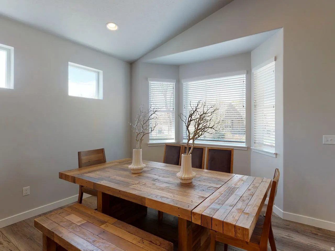 Dining space with lofted ceiling, light wood-style floors, healthy amount of natural light, and recessed lighting