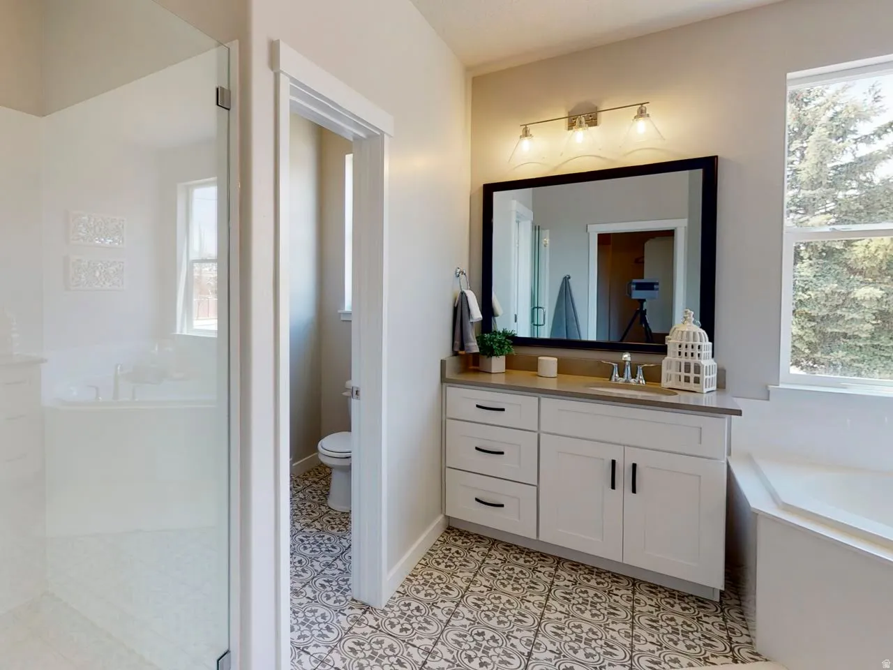 Full bath featuring vanity, a bath, light tile patterned flooring, and walk in shower