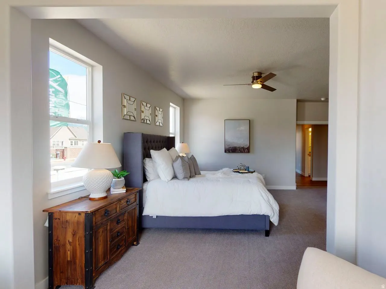 Carpeted bedroom with ceiling fan and baseboards