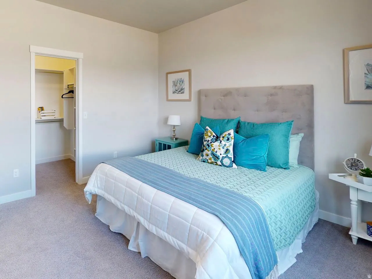 Carpeted bedroom featuring a walk in closet and baseboards
