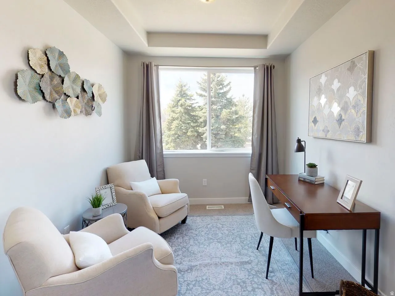 Office space with light colored carpet and a raised ceiling