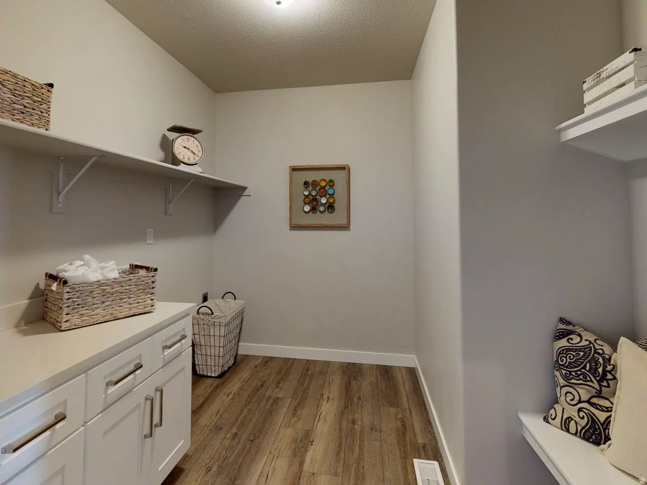 Laundry area featuring light wood-style floors and a textured ceiling