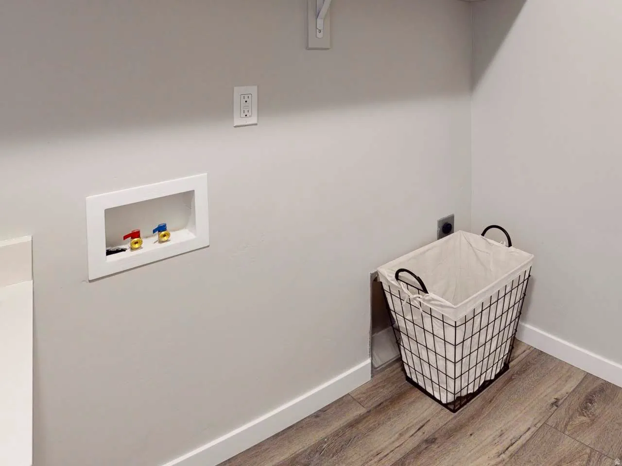 Laundry area with light wood-style flooring and hookup for a washing machine