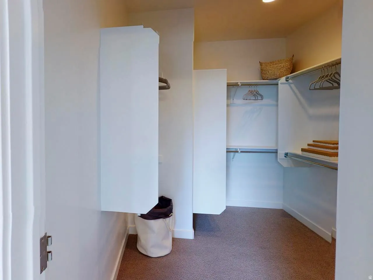 Walk in closet featuring dark carpet