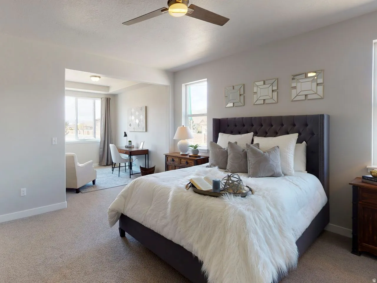 Bedroom featuring multiple windows, light colored carpet, and a ceiling fan
