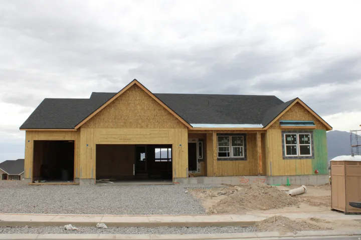 New construction framed home with a multi-gabled roofline and attached two-car garage