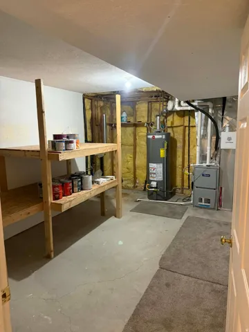 Unfinished below grade area with heating unit and water heater