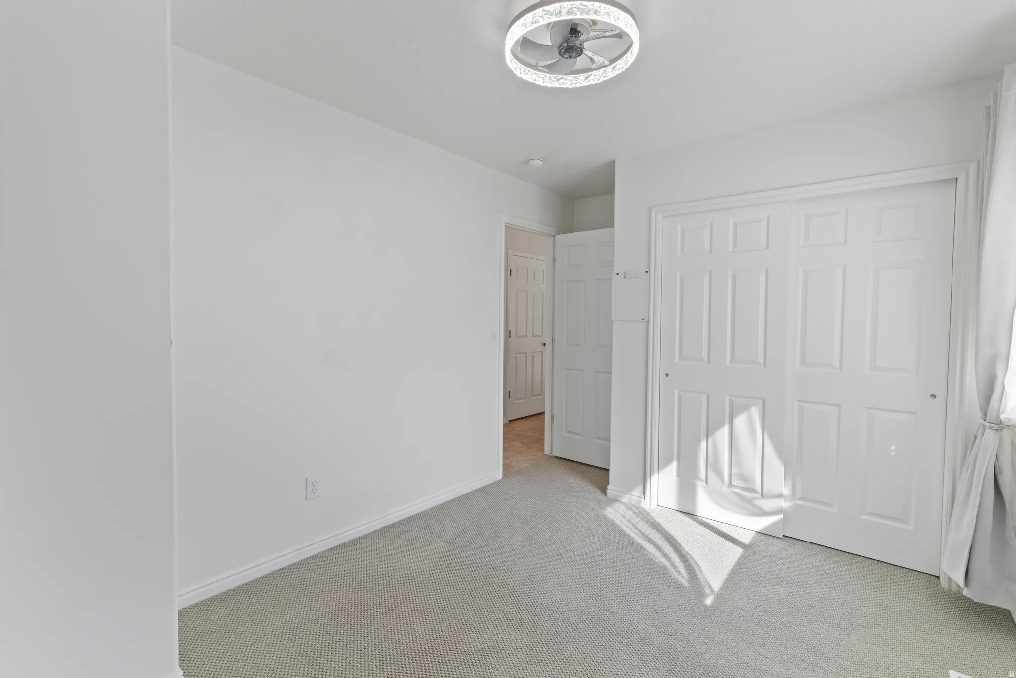 Unfurnished bedroom with light colored carpet and a closet