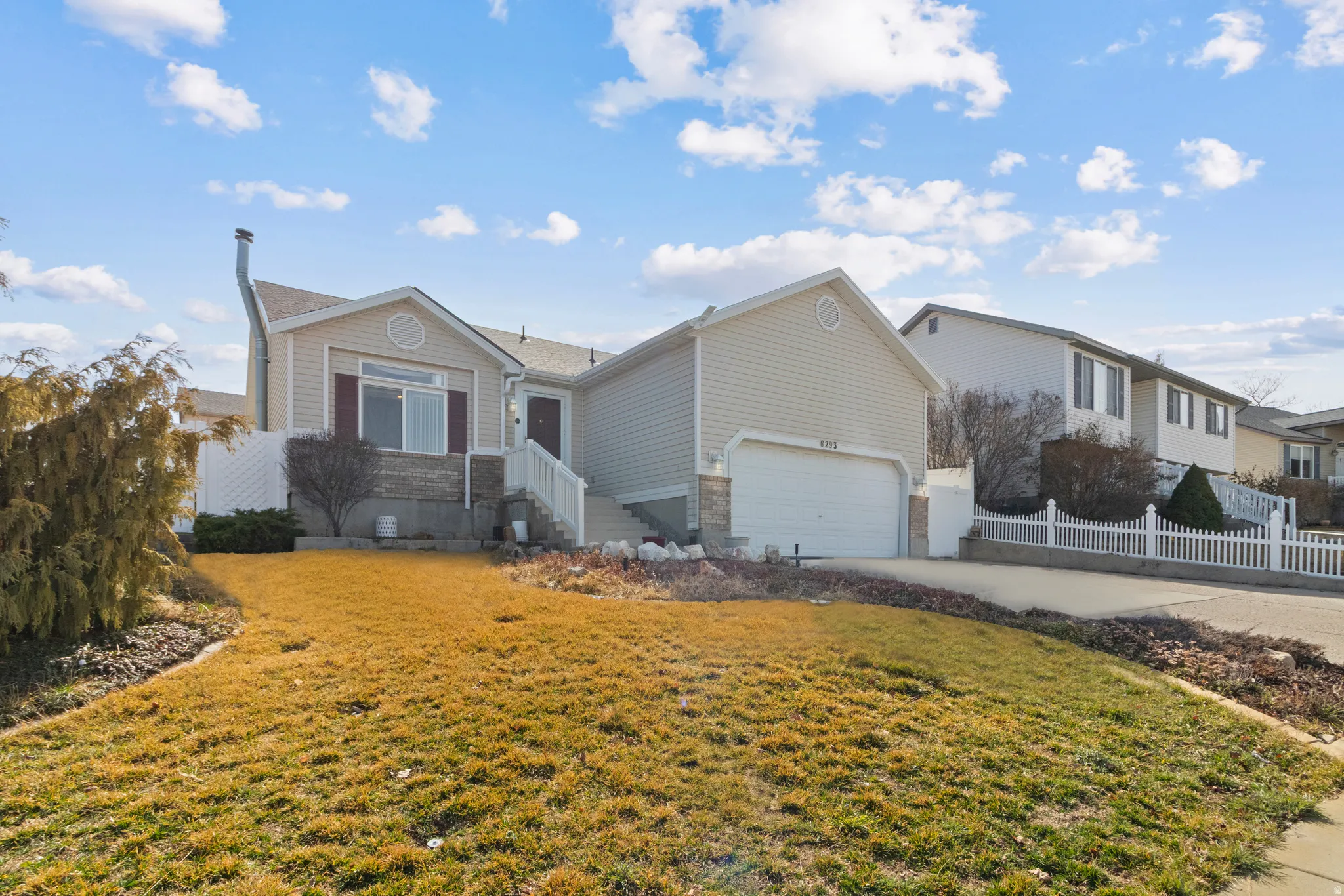 Ranch-style home with concrete driveway and an attached garage