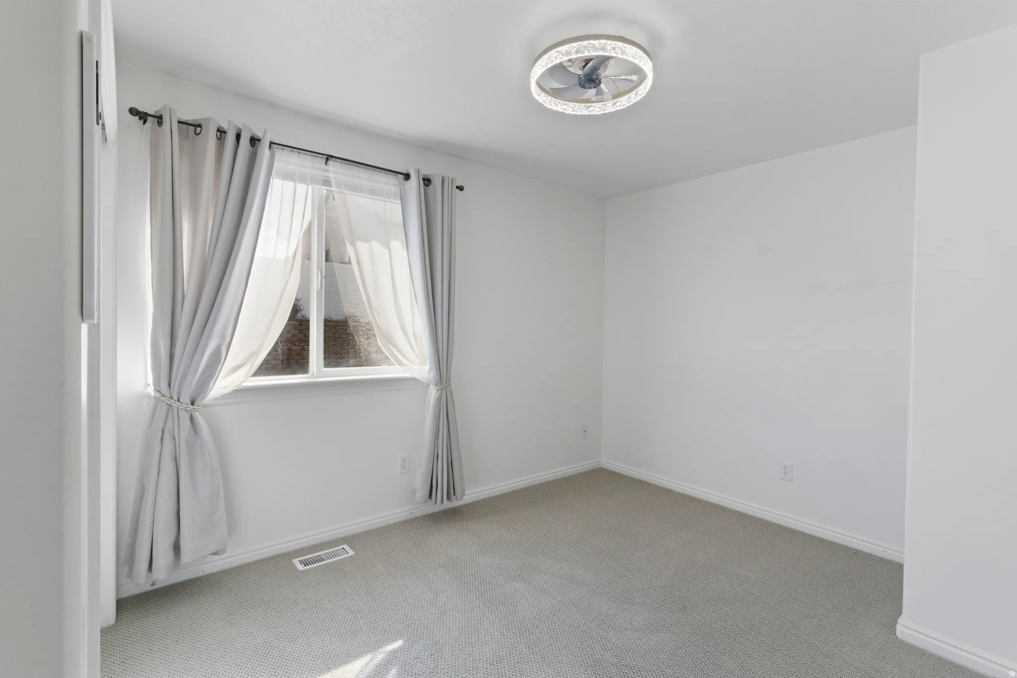 Unfurnished room with light colored carpet and baseboards