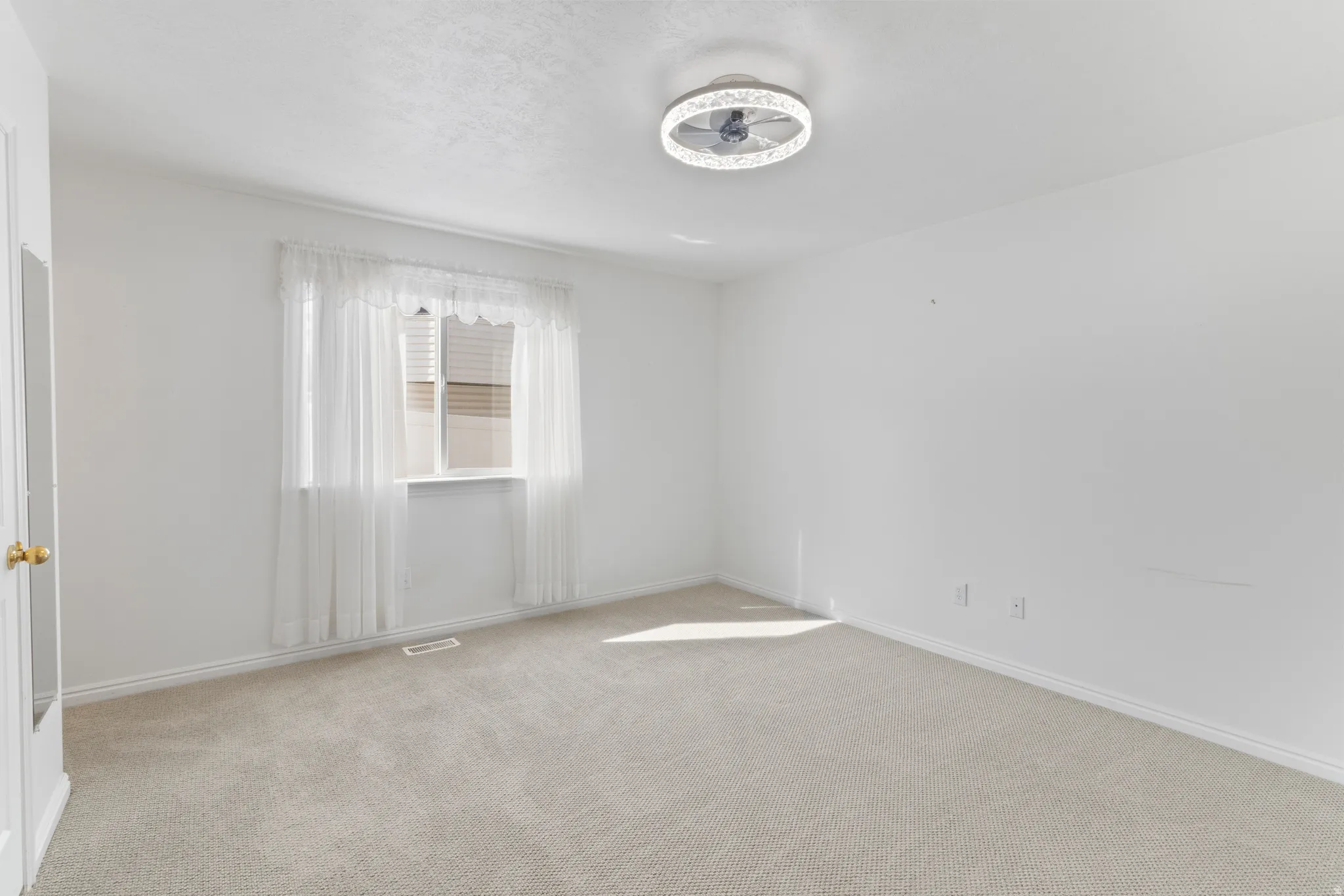Empty room with light carpet and baseboards