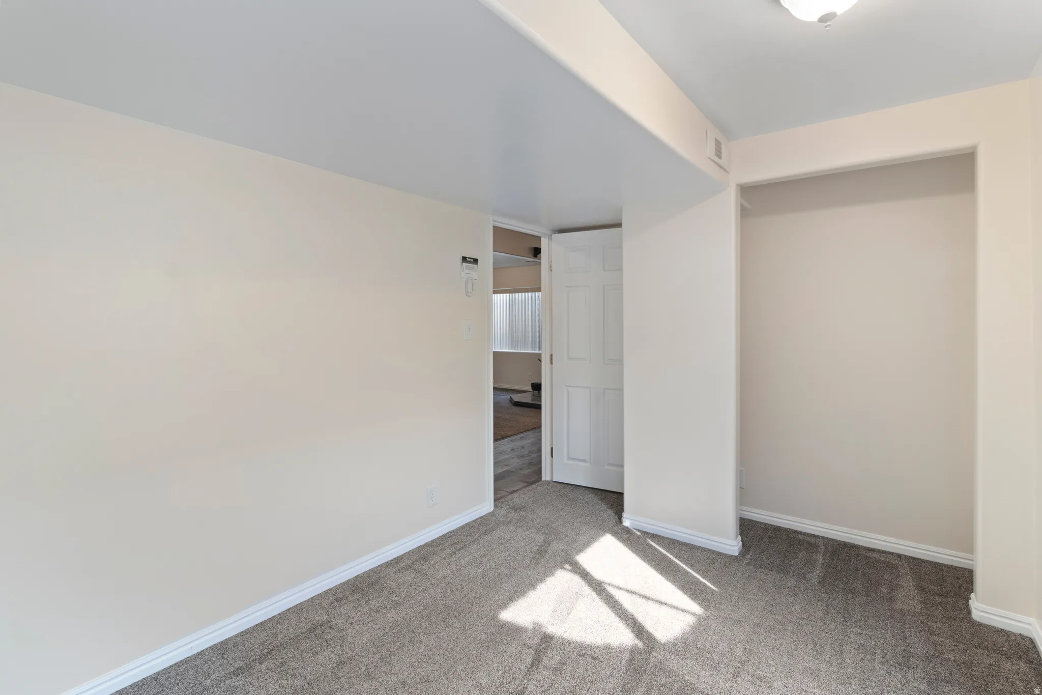 Unfurnished bedroom featuring baseboards and light colored carpet