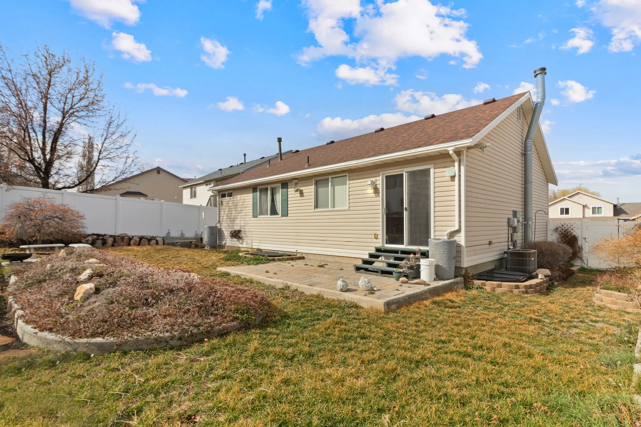 Rear view of house with entry steps, a patio area, and a fenced backyard