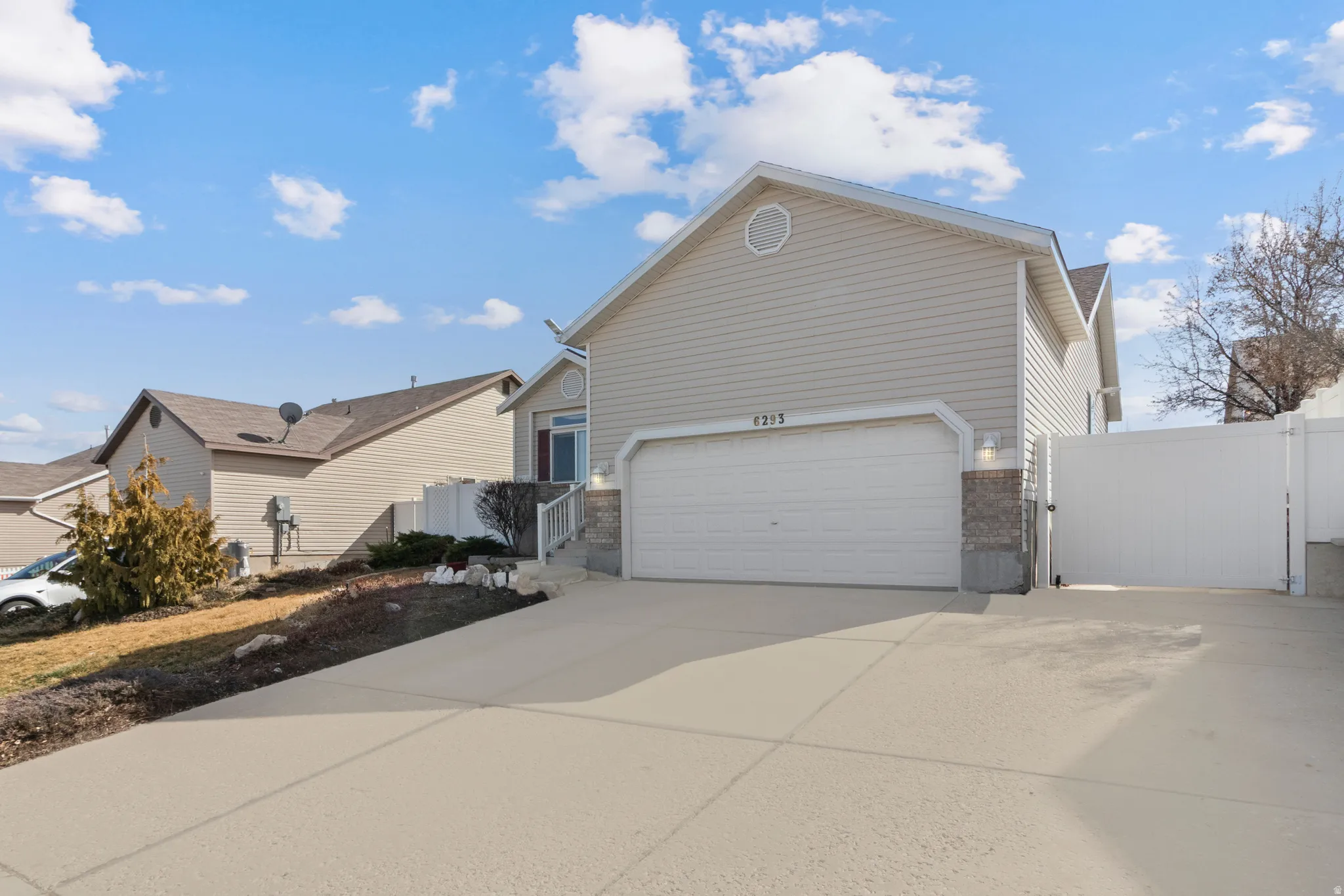 View of property exterior featuring a gate, driveway, and an attached garage