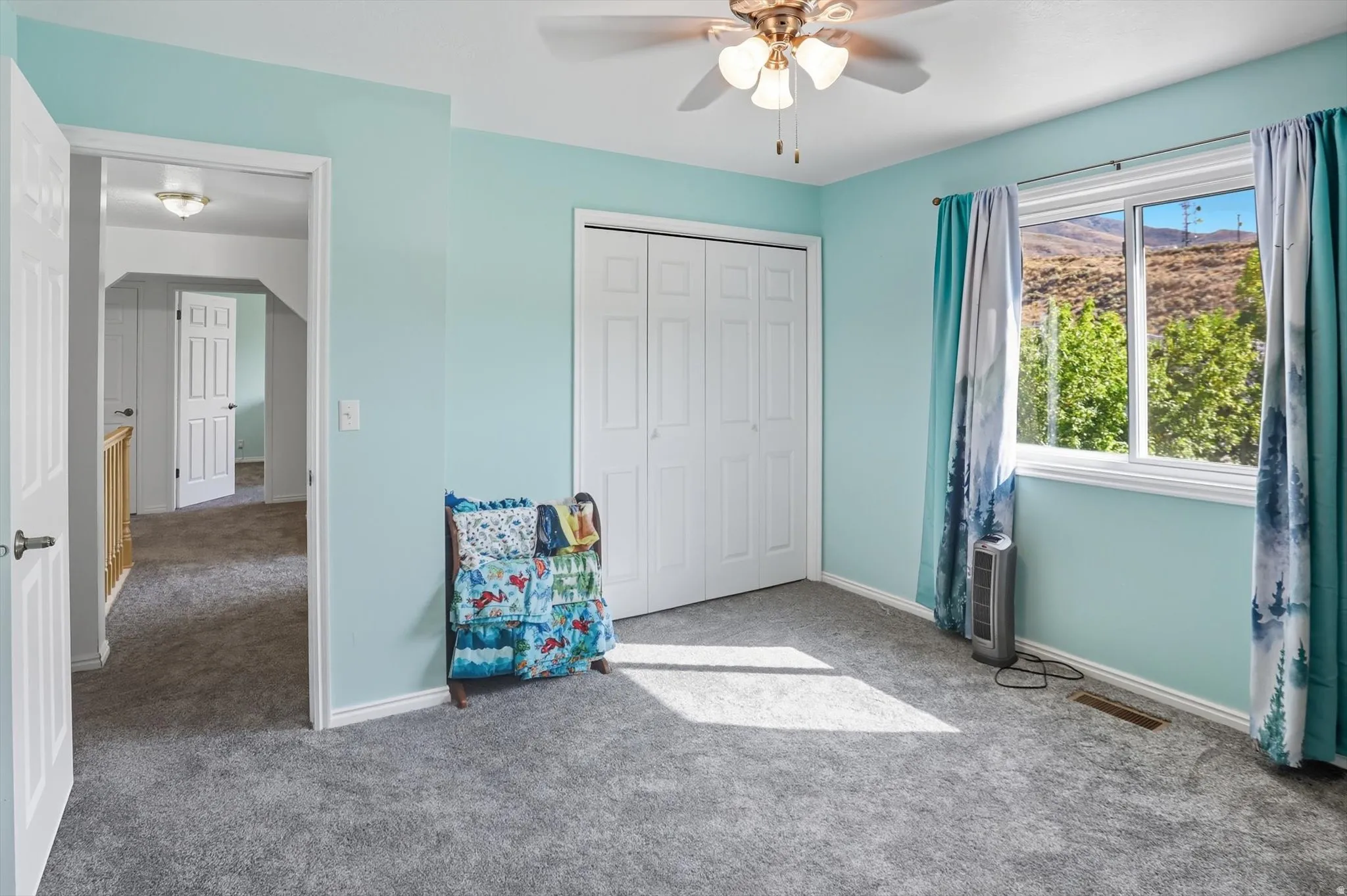 Unfurnished bedroom with carpet floors, a closet, a ceiling fan, and a mountain view