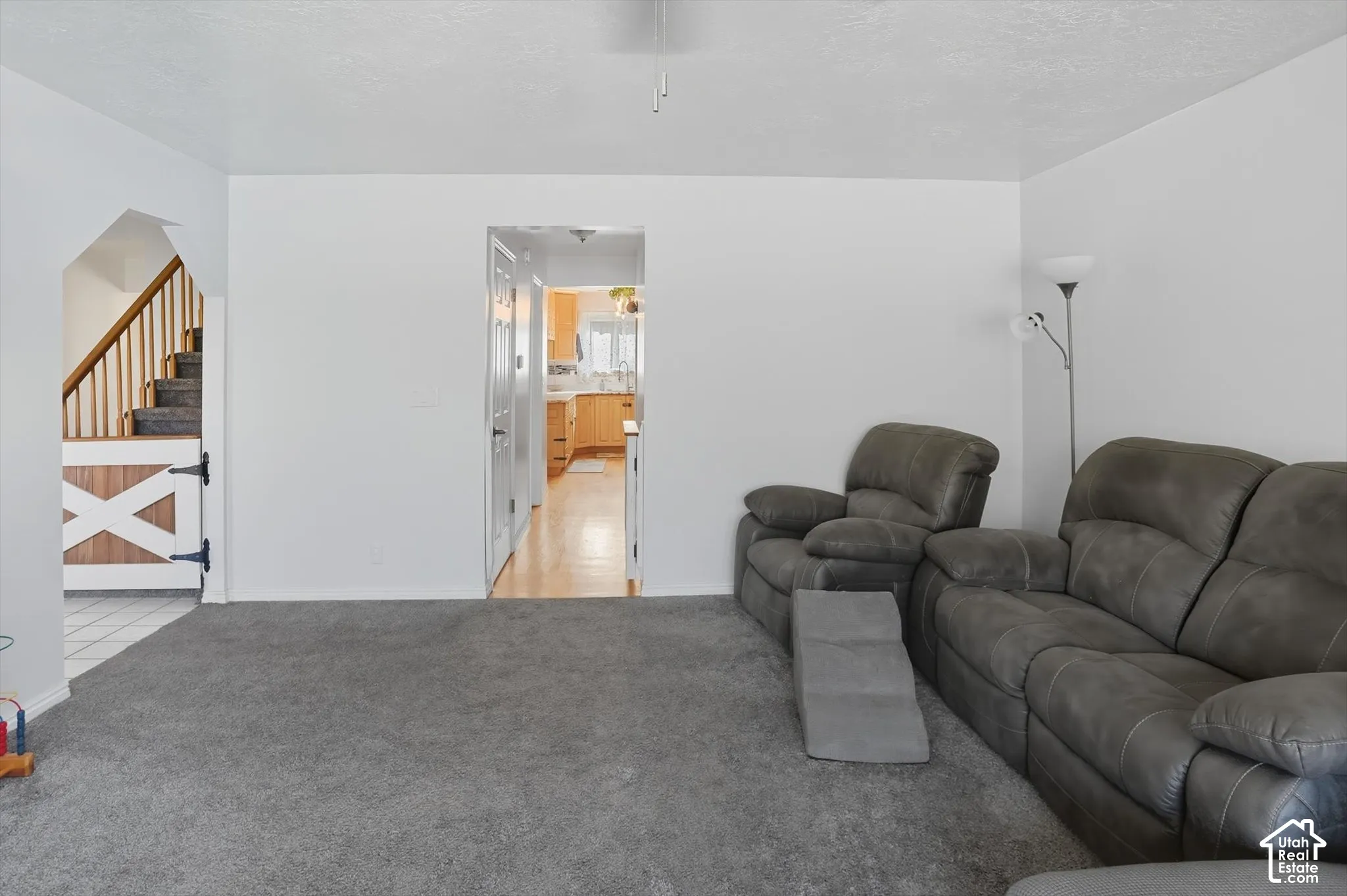 Living area with stairs and light carpet