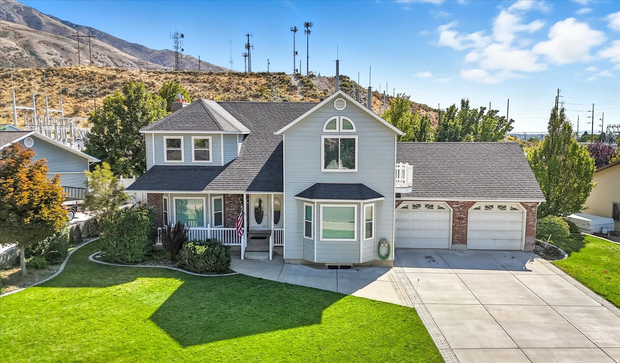 Traditional-style home featuring a front lawn, driveway, roof with shingles, and a garage
