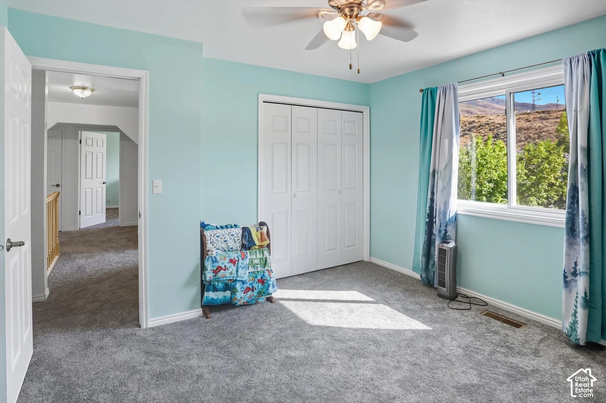 Unfurnished bedroom with carpet floors, a closet, a ceiling fan, and a mountain view