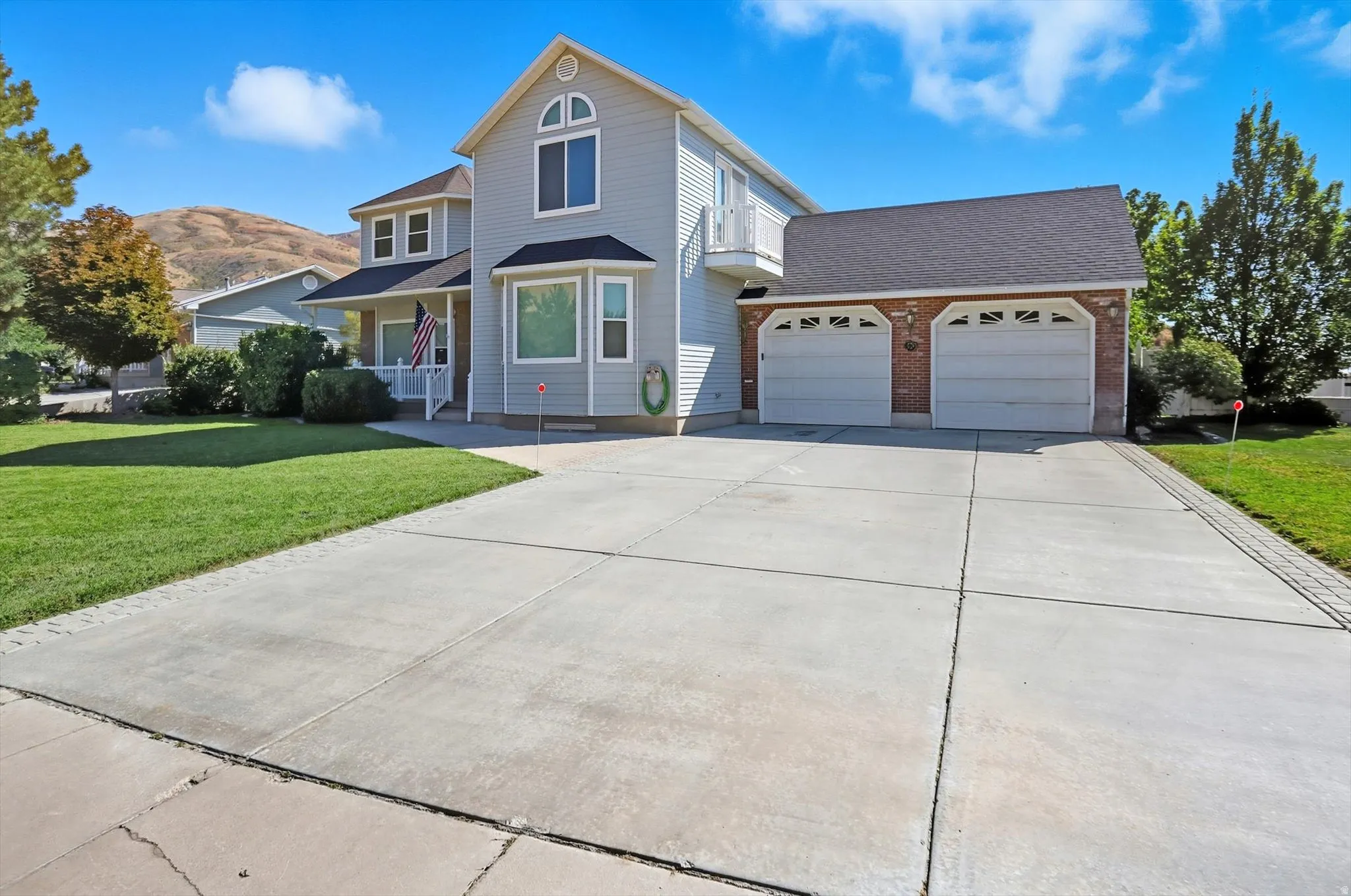 Traditional home with a front lawn, concrete driveway, an attached garage, and roof with shingles