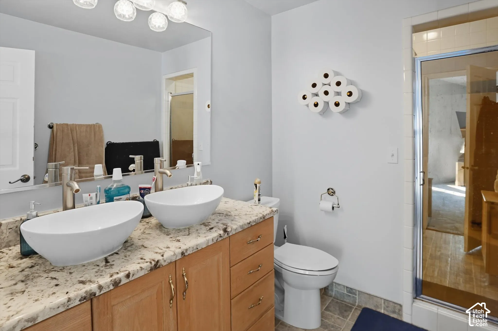 Bathroom featuring a stall shower and double vanity