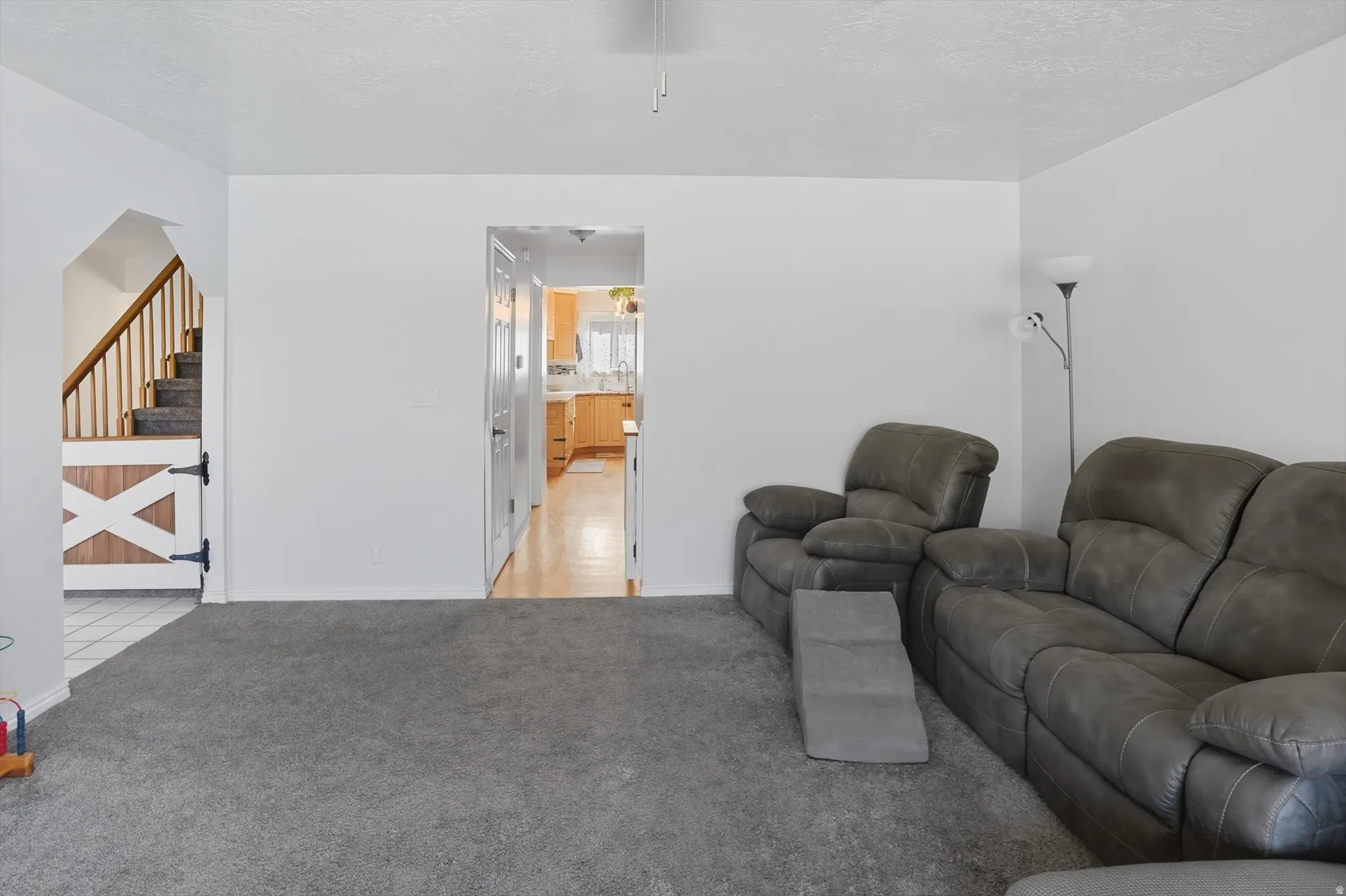Living area with stairs and light carpet