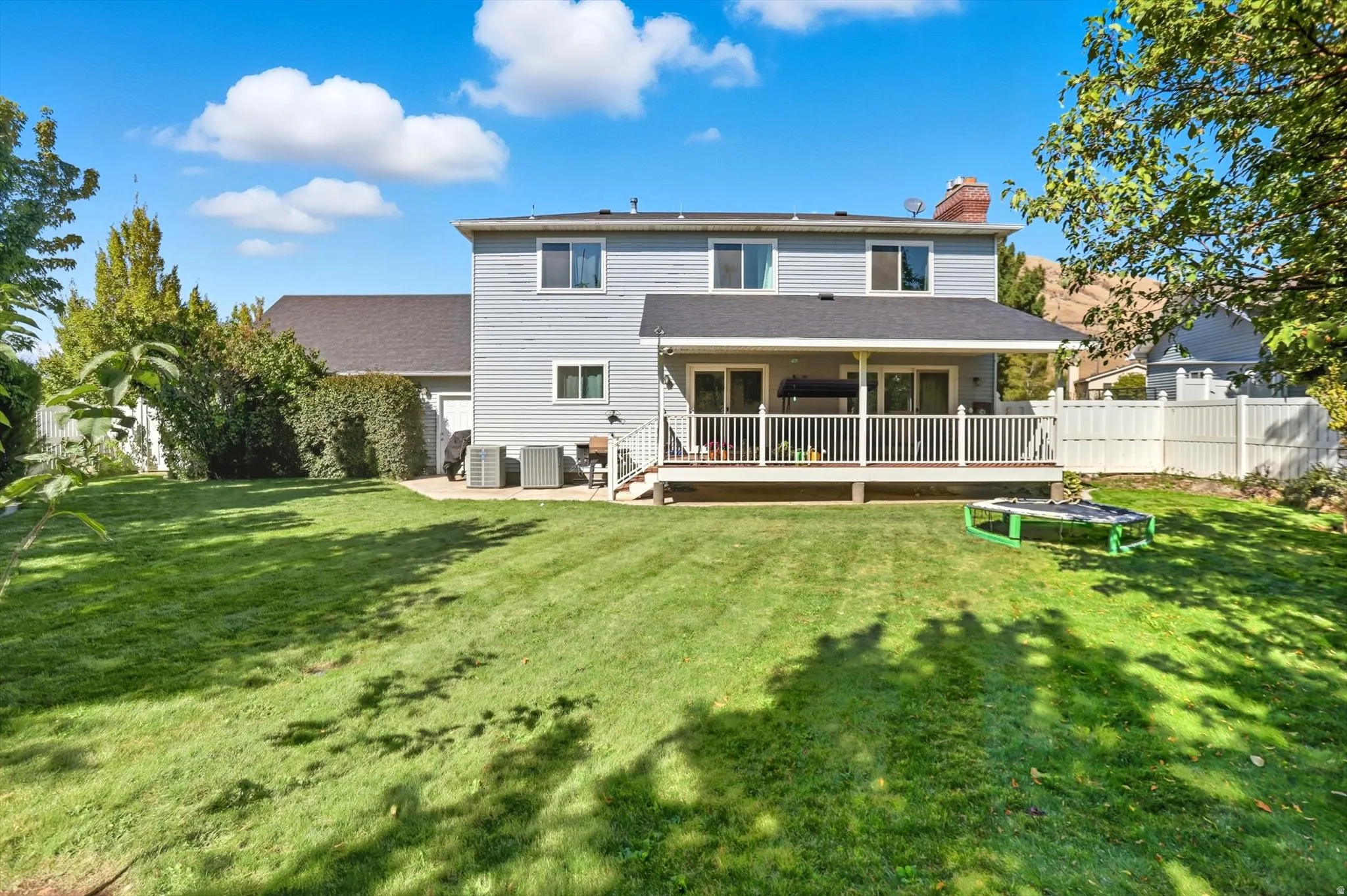 Back of property with a chimney and a deck