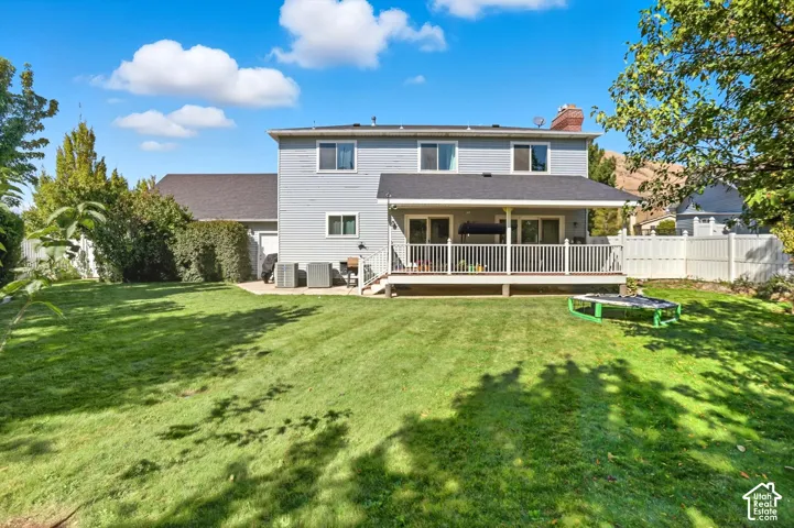 Back of property with a chimney and a deck