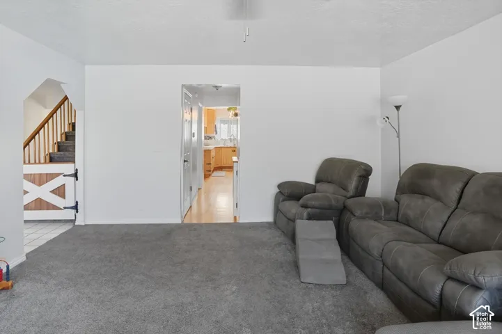 Living area with stairs and light carpet