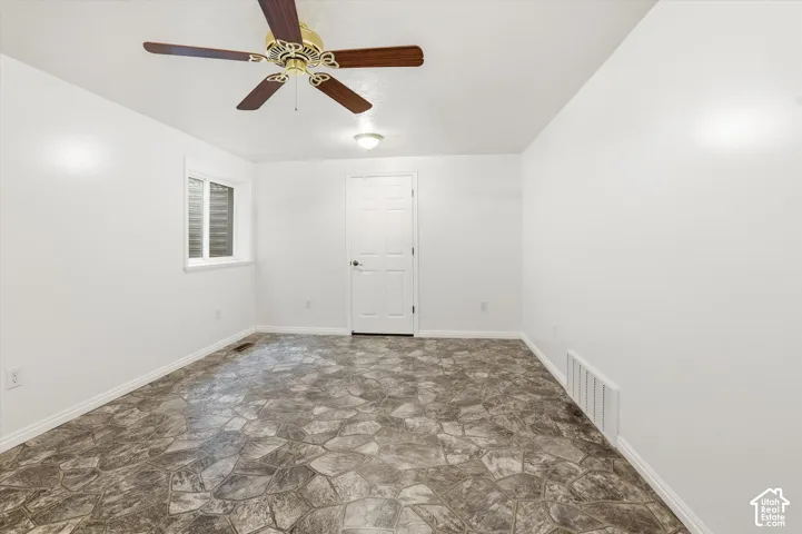 Spare room featuring stone floors and ceiling fan