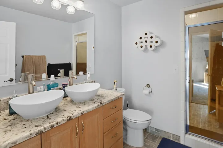 Bathroom featuring a stall shower and double vanity