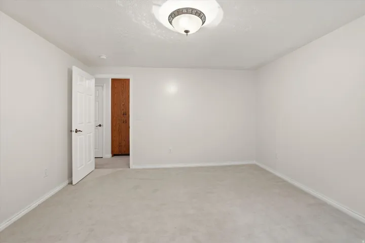 Empty room featuring light carpet and a textured ceiling