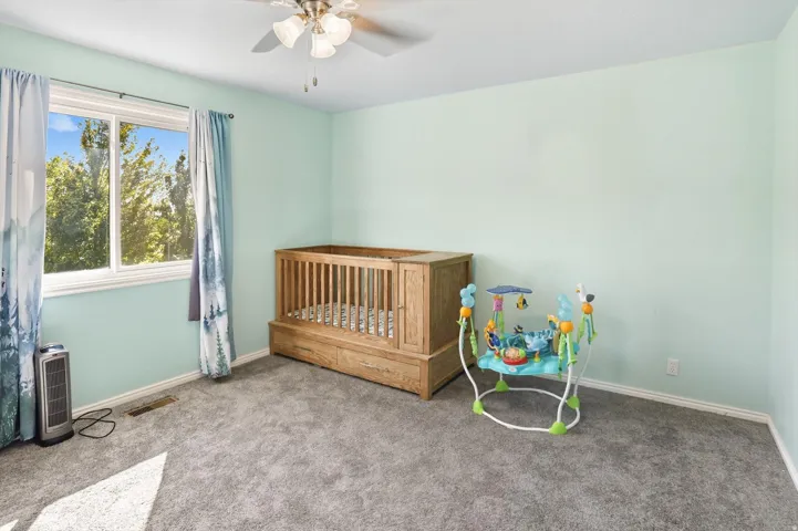 Carpeted bedroom with baseboards and ceiling fan