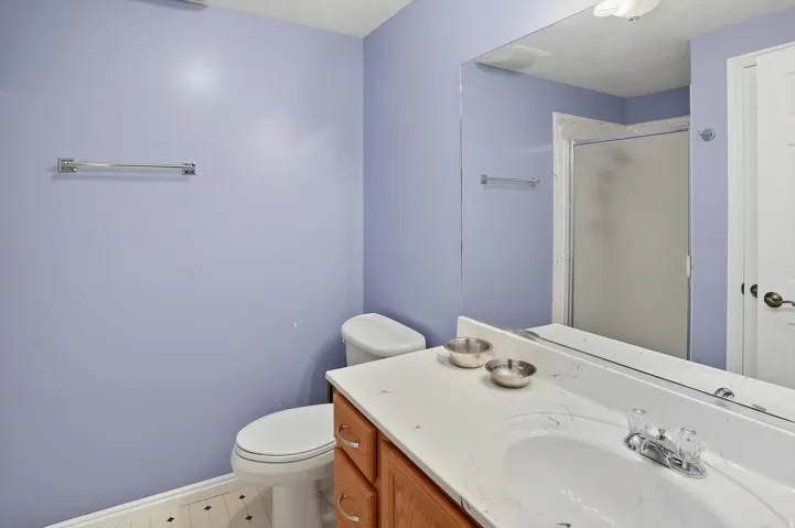 Bathroom with vanity, a stall shower, and light flooring