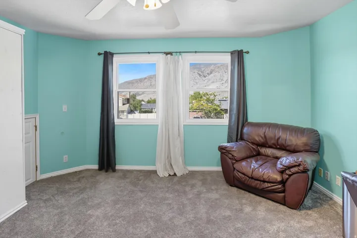 Sitting room with carpet flooring, ceiling fan, and a mountain view