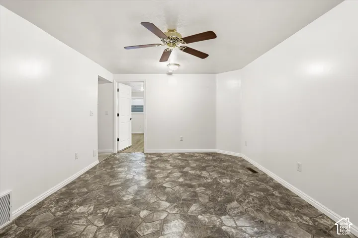 Unfurnished room with stone floors and ceiling fan