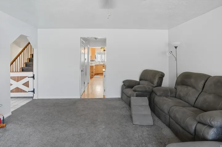 Living area with stairs and light carpet