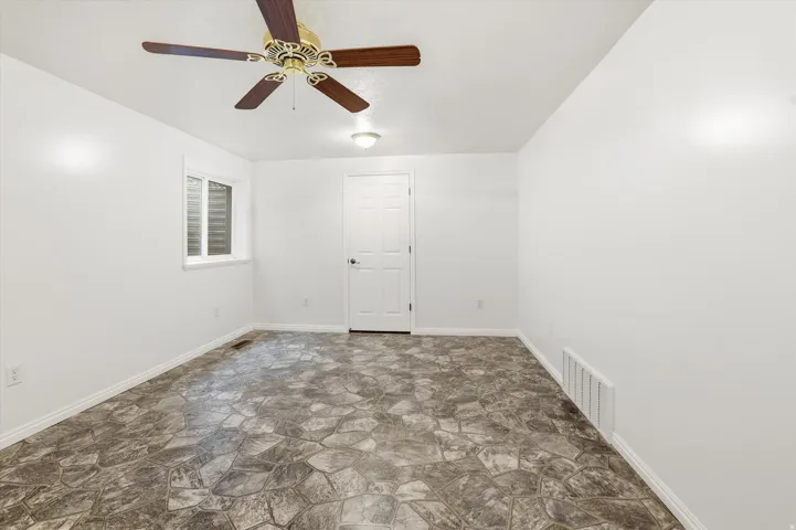 Spare room featuring stone floors and ceiling fan